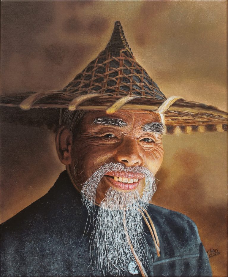 Portrait d'un homme âgé souriant, portant un chapeau conique et une barbe grise.