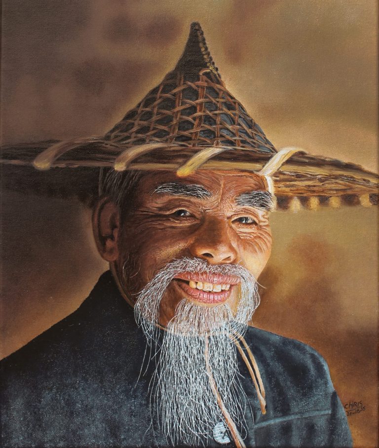 Portrait d'un homme âgé souriant, portant un chapeau conique et une barbe grise.