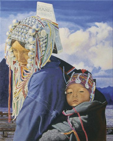 Femme portant un enfant, tous deux vêtus de costumes traditionnels colorés.