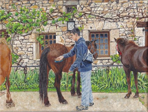 Un homme brosse un cheval près d'une maison en pierre, entouré d'autres chevaux.