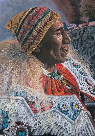 Homme en tenue traditionnelle ornée de perles et plumes, portant un bonnet coloré.