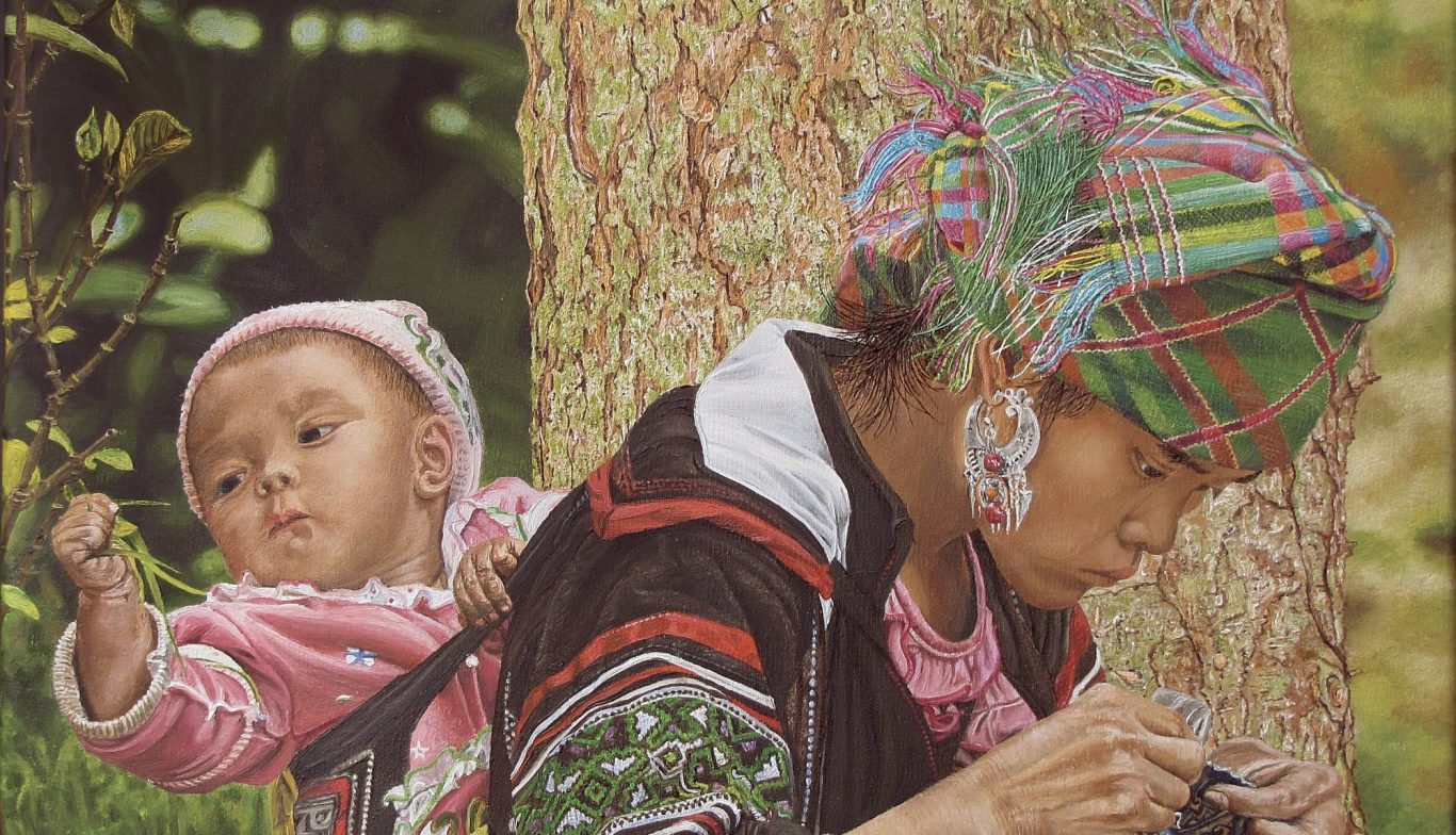 Femme en tenue traditionnelle portant un bébé dans son dos, s'occupant près d'un arbre.