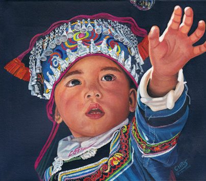 Un enfant en vêtements traditionnels tend la main vers une bulle.