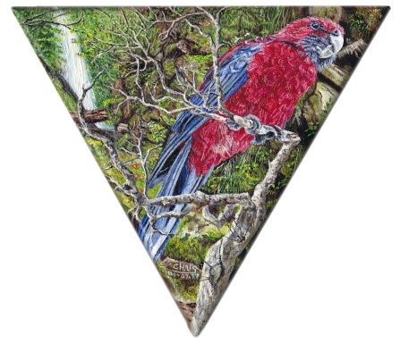 Perroquet coloré perché sur une branche, entouré de feuillage verdoyant.