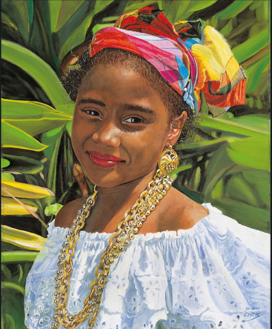 Femme souriante avec un foulard coloré et des bijoux, entourée de plantes verdoyantes.