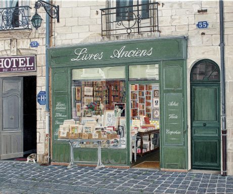 Librairie avec des livres et des cartes exposés, devant une façade verte.