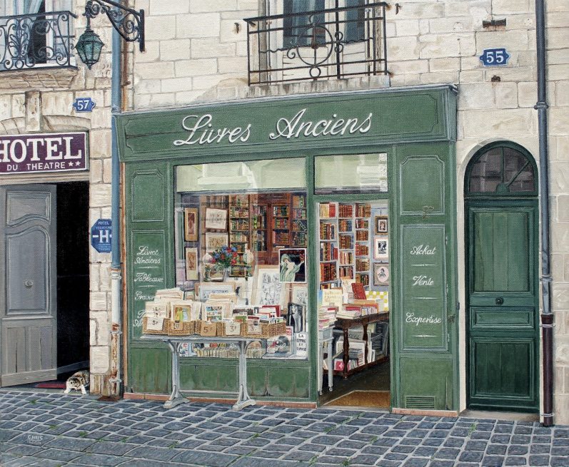 Boutique de livres avec une façade verte, présentée sur une rue pittoresque.